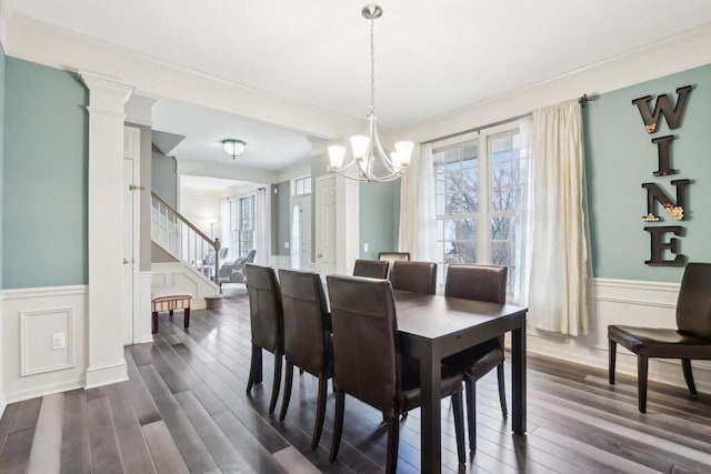 dining room featuring crown molding, a chandelier, stairway, wainscoting, and dark wood-style floors