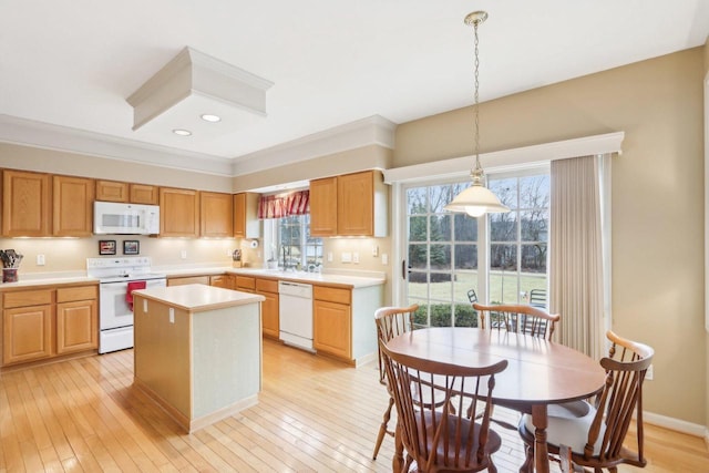 kitchen with a kitchen island, pendant lighting, light wood-type flooring, light countertops, and white appliances