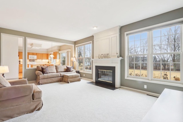 living room featuring visible vents, carpet floors, baseboards, and a fireplace