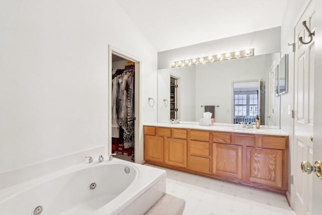 full bathroom with double vanity, a sink, vaulted ceiling, tile patterned floors, and a jetted tub