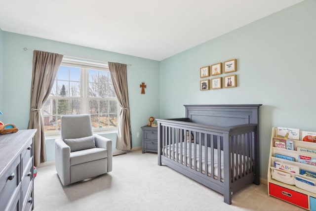 bedroom featuring a crib and light carpet