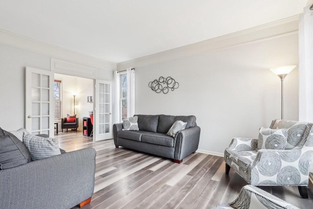 living room featuring french doors, baseboards, and wood finished floors