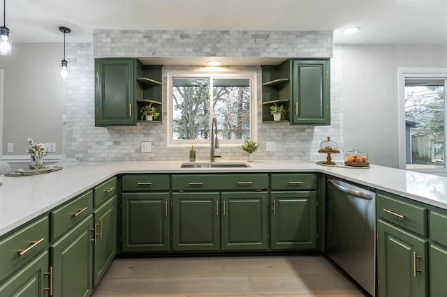 kitchen featuring open shelves, a sink, stainless steel dishwasher, a peninsula, and green cabinetry