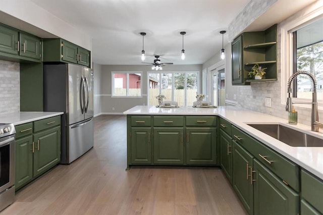 kitchen with a sink, appliances with stainless steel finishes, and green cabinets