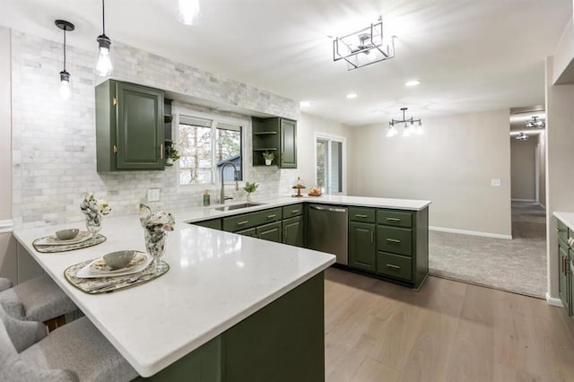 kitchen featuring a sink, stainless steel dishwasher, a peninsula, and green cabinets