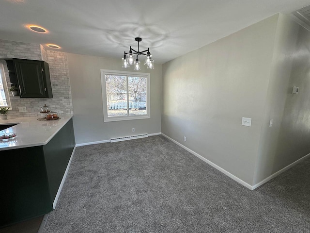 unfurnished dining area featuring baseboards, carpet floors, baseboard heating, and a chandelier