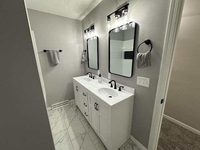 bathroom featuring baseboards, visible vents, marble finish floor, and a sink