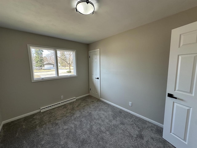 unfurnished room with a baseboard heating unit, carpet floors, and baseboards