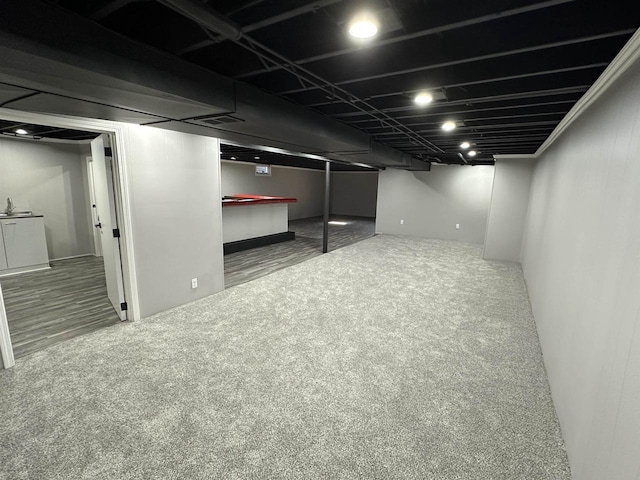 finished basement featuring visible vents and carpet flooring