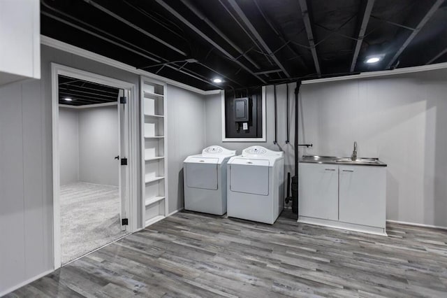 laundry area with cabinet space, a sink, washing machine and dryer, and wood finished floors