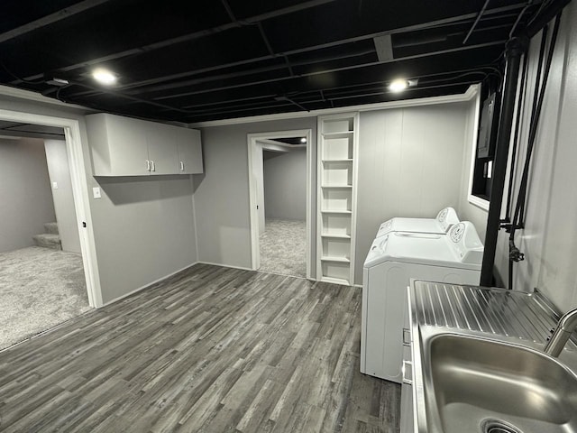 laundry room with dark wood-style floors, cabinet space, washer and dryer, and a sink