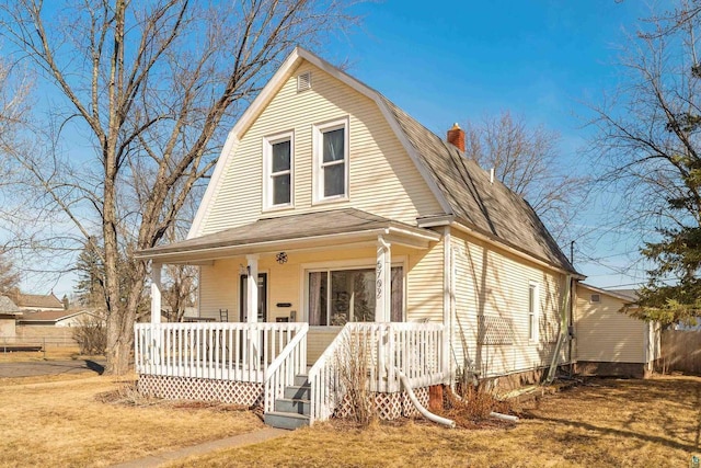 colonial inspired home with covered porch, a gambrel roof, and a shingled roof