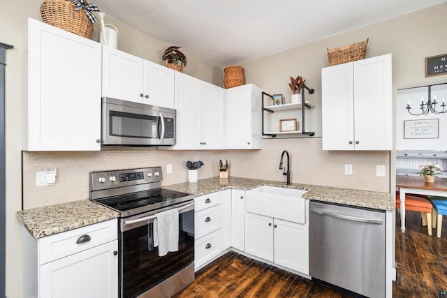 kitchen featuring white cabinets, open shelves, stainless steel appliances, and a sink