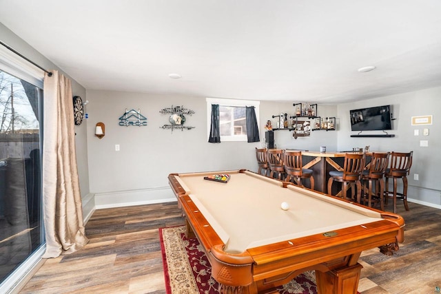 rec room with a dry bar, wood finished floors, and baseboards