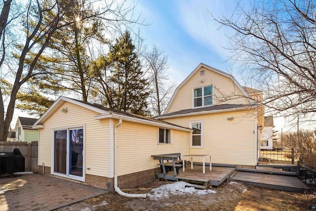 back of property featuring a deck, a patio, fence, and a gambrel roof