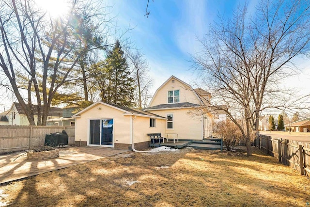 back of property with a patio area, a gambrel roof, a fire pit, and a fenced backyard