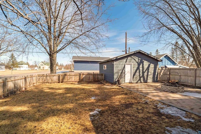 view of yard featuring an outbuilding, a patio, and a fenced backyard