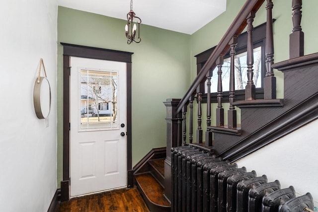 foyer featuring radiator, stairs, baseboards, and wood finished floors