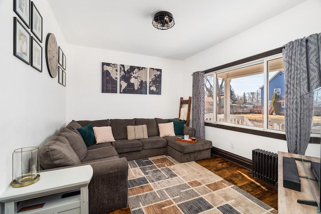 living room featuring radiator heating unit, dark wood-style floors, and baseboards