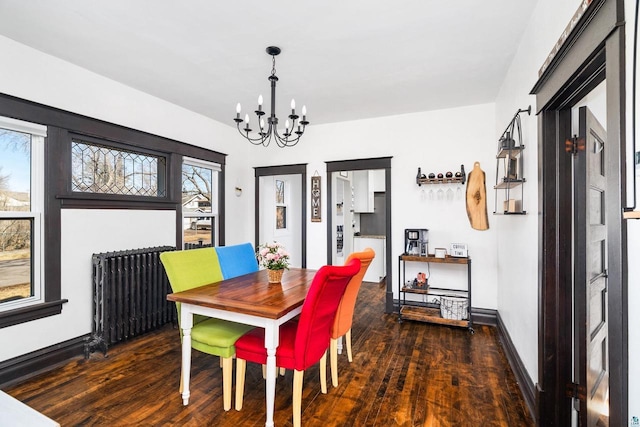 dining area with a notable chandelier, radiator, baseboards, and wood finished floors