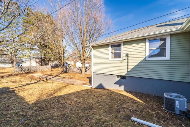 view of yard featuring central AC and fence