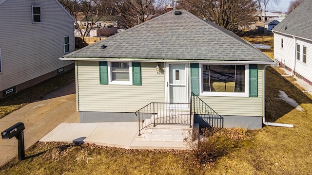 view of front facade with roof with shingles and entry steps