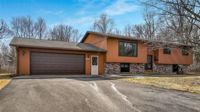 view of front of house with driveway, brick siding, and an attached garage