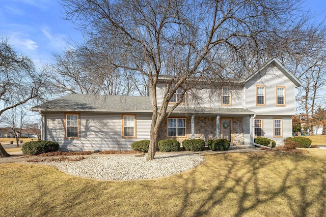 traditional home with a shingled roof and a front lawn