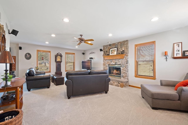 living room featuring recessed lighting, baseboards, light carpet, and a stone fireplace