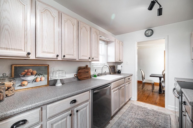 kitchen featuring light countertops, baseboards, appliances with stainless steel finishes, and a sink