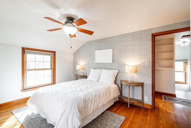 bedroom featuring vaulted ceiling, a ceiling fan, baseboards, and wood finished floors