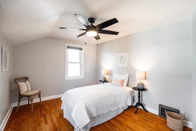 bedroom with visible vents, baseboards, wood finished floors, and vaulted ceiling