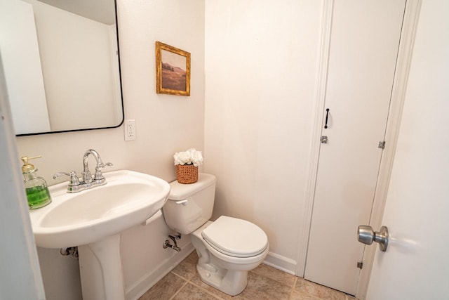 bathroom featuring tile patterned floors, toilet, and baseboards