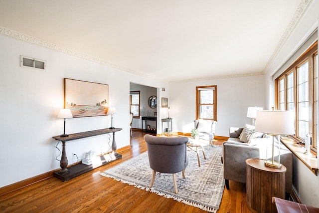 living area featuring a fireplace, wood finished floors, visible vents, and a healthy amount of sunlight