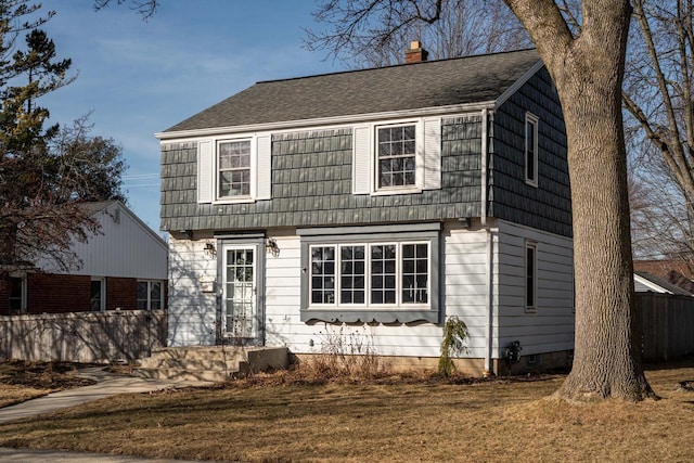 colonial inspired home with crawl space, a chimney, a front yard, and fence