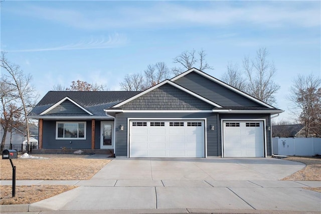 ranch-style house featuring driveway, a garage, and fence