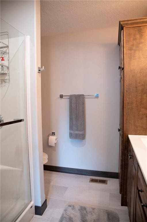 full bathroom with tile patterned floors, visible vents, a stall shower, a textured ceiling, and vanity