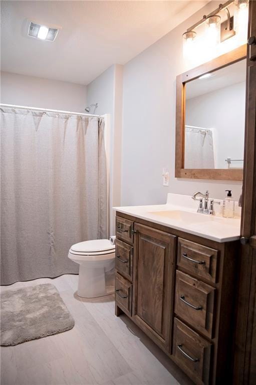 bathroom with visible vents, toilet, curtained shower, and vanity