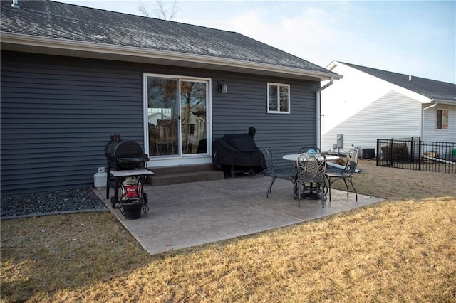 back of property featuring a patio, roof with shingles, a yard, and fence