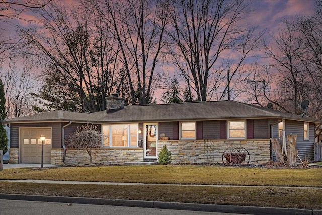 view of front of house with a garage, stone siding, and a front lawn