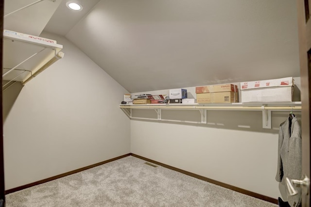 spacious closet featuring vaulted ceiling, carpet flooring, and visible vents