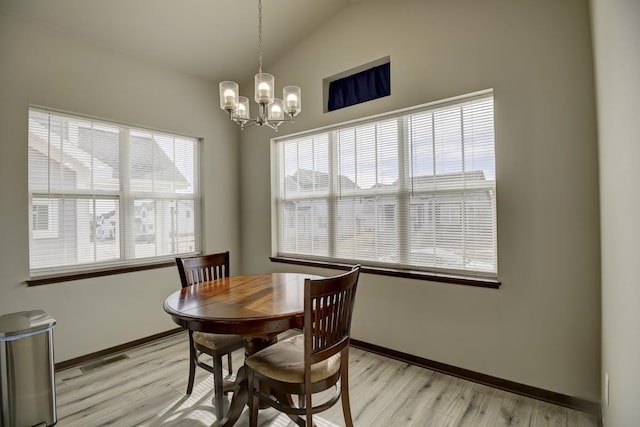 dining room with visible vents, plenty of natural light, lofted ceiling, and light wood-style flooring