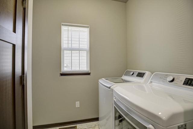 laundry area with laundry area, visible vents, baseboards, and washer and clothes dryer