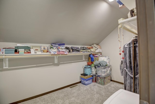 walk in closet featuring carpet and vaulted ceiling