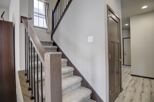 stairs with recessed lighting, baseboards, and wood finished floors