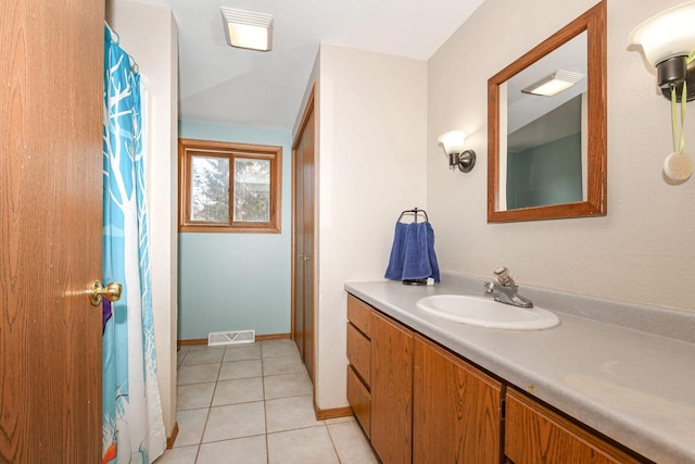 bathroom featuring tile patterned floors, visible vents, baseboards, and vanity