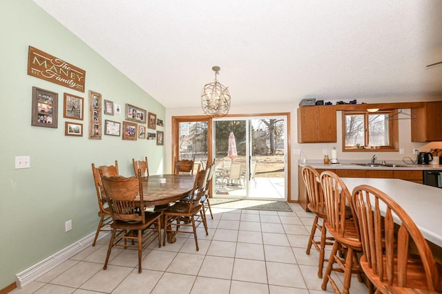 dining area featuring lofted ceiling, light tile patterned floors, baseboards, and a chandelier