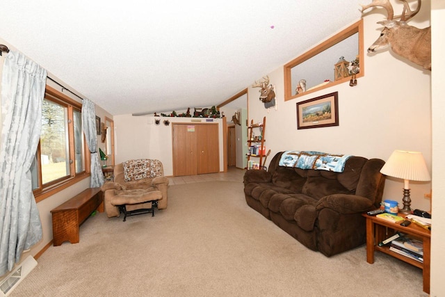 living room with visible vents, light colored carpet, a textured ceiling, and vaulted ceiling