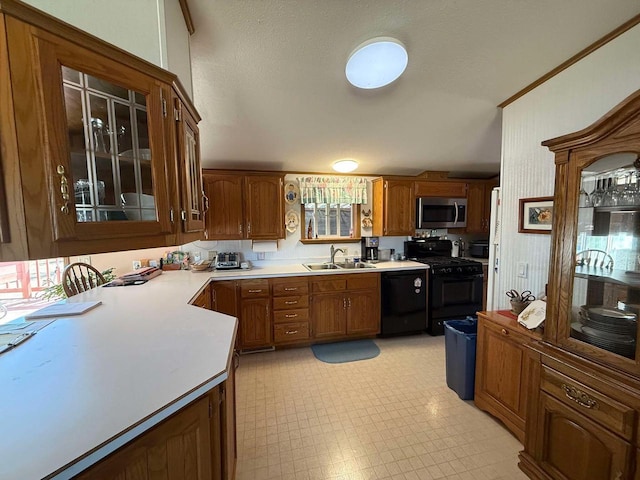 kitchen featuring black gas range, stainless steel microwave, a sink, light countertops, and dishwasher