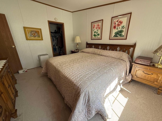 bedroom featuring a spacious closet, ornamental molding, a closet, and carpet floors